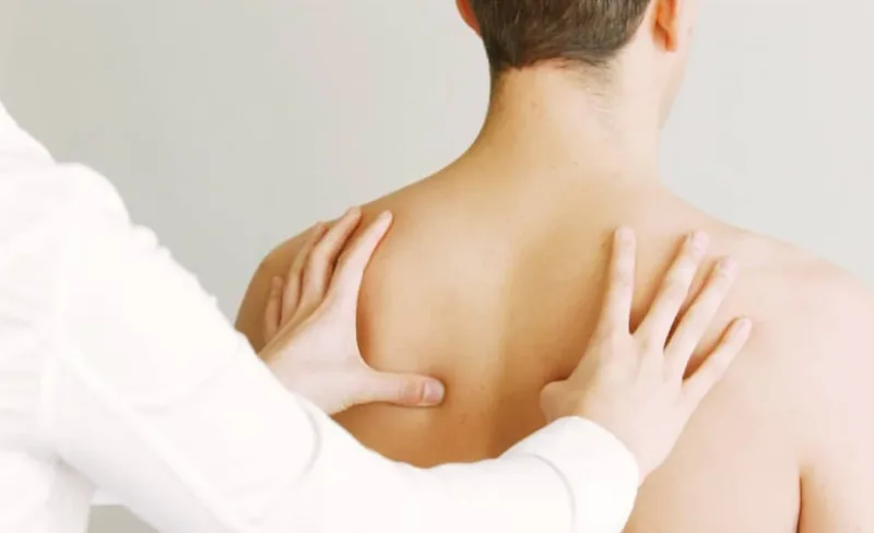 Registered massage therapist applying hands-on treatment to a client's upper back and shoulders at Multidimensional Health, Nanaimo, BC.